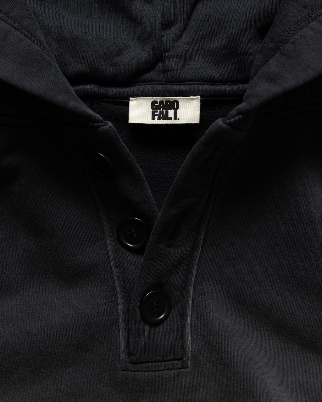 Men's heavyweight hoodie in black, corozo button placket and label detail